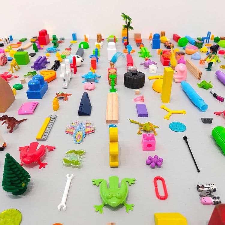 小さなおもちゃやパーツなどを整然と敷きつめた、ライアン・ガンダーの作品《閉ざされた世界》(2024)(部分)