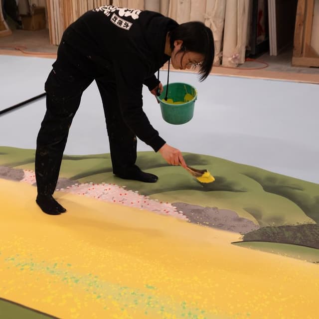 「女殺油地獄」序幕「徳庵堤の場」の背景画を描く大道具スタッフ