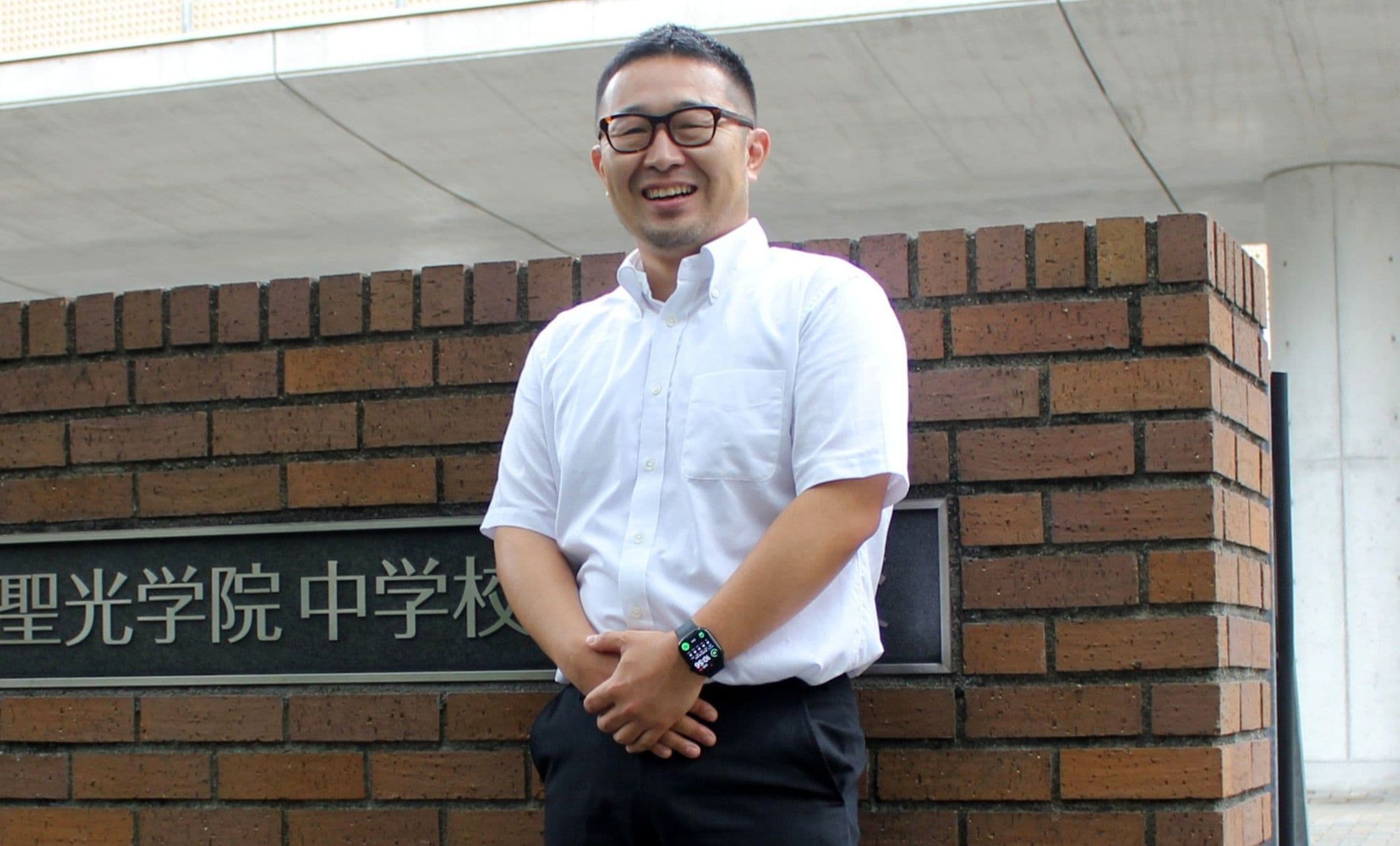 聖光学院の校門前に立つ高木俊輔さん＝2026年8月31日、横浜市中区、古屋聡一撮影